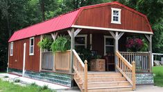 a small house with a red roof and wooden steps