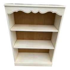 a white wooden shelf with three shelves