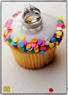 two wedding rings sitting on top of a cupcake