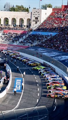 the cars are lined up on the race track in front of an audience at a sporting event