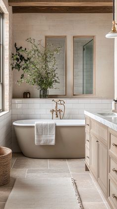 a bathroom with a bathtub, sink and two mirrors on the wall above it