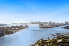 an aerial view of a city and the ocean with tall buildings in the distance,