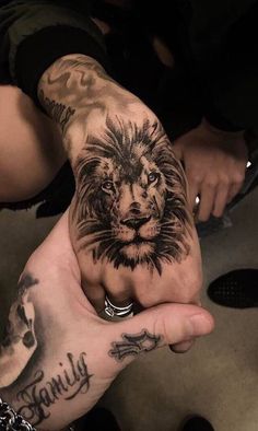 a man holding his hand with a lion tattoo on it