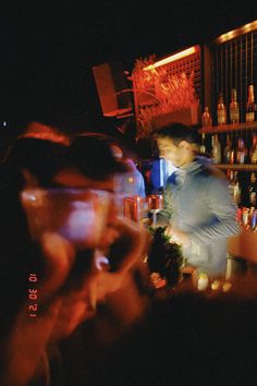 a man standing in front of a bar talking on a cell phone