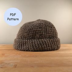 a knitted hat sitting on top of a wooden table