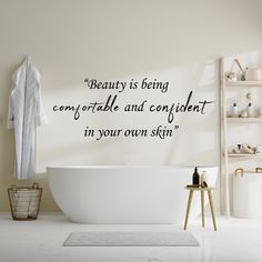 a bathroom with a bathtub and wall decal that says, beauty is being comfortable and confident in your own skin