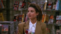 a woman standing in front of a book shelf