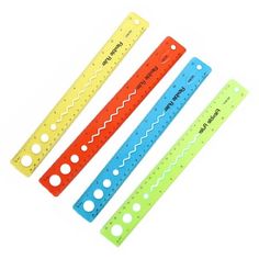 three different colored rulers with holes on each side and one measuring ruler in the middle