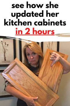 a woman holding up some wooden cabinets in her hands