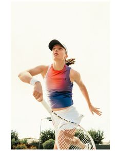 a female tennis player is swinging her racket at the ball in mid air,