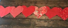 several red hearts hanging on a wooden wall