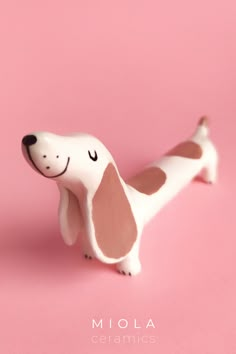 a dog figurine on a pink background with the words mola ceramics above it