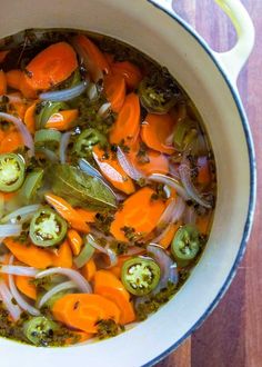 a pot filled with vegetables on top of a wooden table