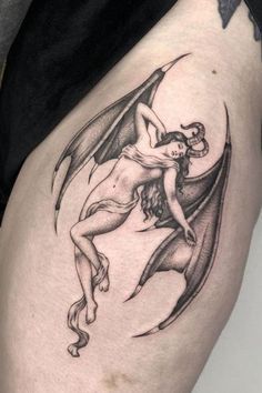 a woman with a bat tattoo on her thigh