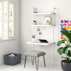 a white desk with a laptop on it next to a potted plant