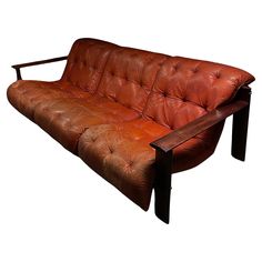 a brown leather couch sitting on top of a wooden frame