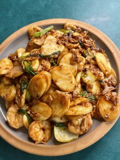 a white plate topped with fried vegetables on top of a blue table