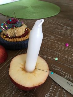 an apple that has been cut in half and is sitting on a table next to a knife