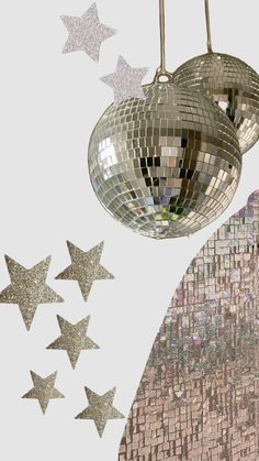 disco ball and stars hanging from the ceiling in front of a white background with silver glitter