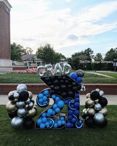 the number twenty four is decorated with blue and silver balloons in front of a building