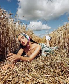 a woman laying in the middle of a corn field