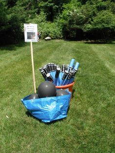 an inflatable ball and glove holder is on the grass near a sign that says,