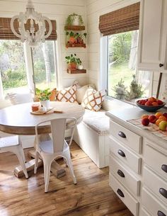 a kitchen filled with lots of furniture and fruit on top of a countertop next to a window