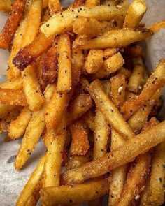 a pile of french fries with seasoning on top