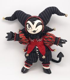 a stuffed animal is dressed in black and red