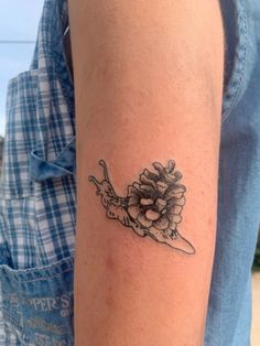 a woman's arm with a tattoo on it that has flowers in the middle