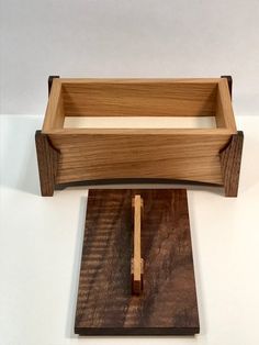 a wooden box with a long handle on top of it and a piece of wood in the middle