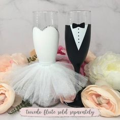 two wine glasses decorated with tuxedo and bride's veil, one is black and the other is white