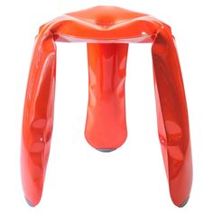 an orange plastic stool that looks like it is bent over