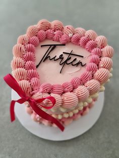 there is a cake that has been decorated with pink and white icing on it