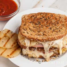 a grilled cheese sandwich on a plate with some french fries and ketchup