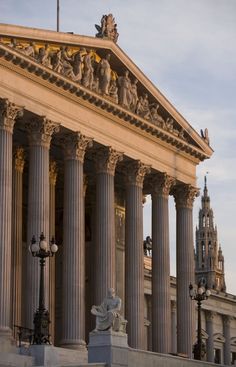 an old building with columns and statues on the front