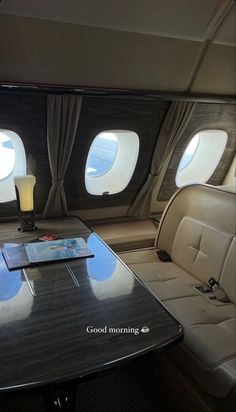 the inside of an airplane with two seats and a table in front of it that has drinks on it