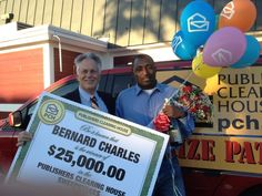 two men standing in the back of a truck holding a large check for $ 25, 000