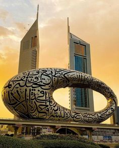 the large sculpture is made to look like a giant o - ring in front of a tall building