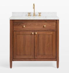 a bathroom vanity with marble top and two brass faucets