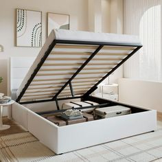 an open white bed frame with drawers and mattresses on the floor in a room