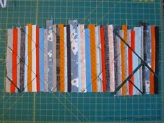 strips of fabric are laid out on a cutting board to be used as wall hangings