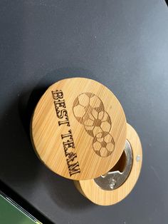 a wooden bottle opener on top of a black counter with the words best beer in it