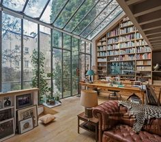 a home office with lots of bookshelves and glass doors leading to the outside