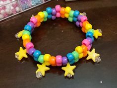 a bracelet made out of plastic beads with stars on the front and back, sitting on top of a table