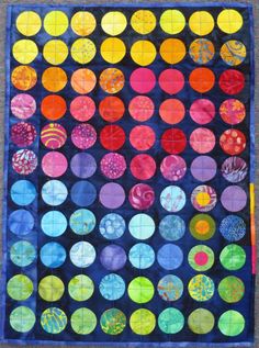 a quilt made with different colored circles on the front and back, along with black background