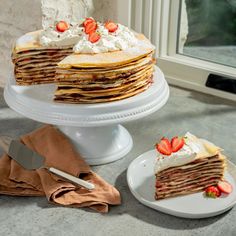 a stack of pancakes with whipped cream and strawberries on top