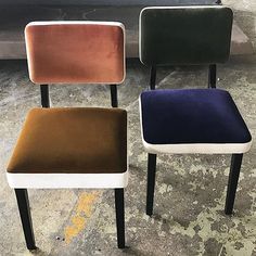 three different colored chairs sitting next to each other