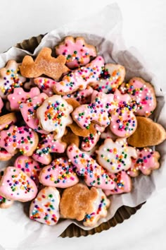 a bowl full of heart shaped cookies with sprinkles