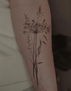 a woman's arm with a flower tattoo on the back of her left arm